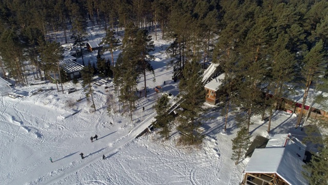 航拍:游客们在白雪覆盖的贝加尔湖上欣赏树木和房屋视频素材