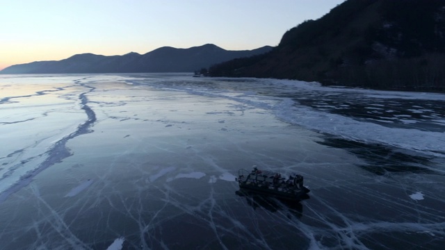 航拍:日落时分，无人机沿着漂浮在贝加尔湖上的气垫船移动视频素材