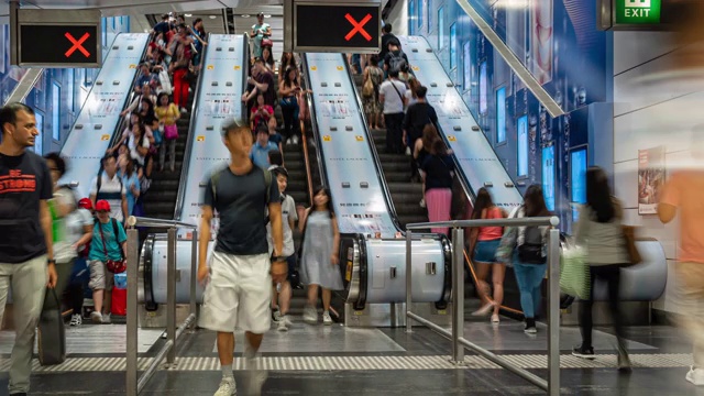 在香港中环车站高峰时段，乘客和游客在自动扶梯上行走和奔跑的4K时间间隔视频素材