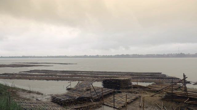 在水中储存用于桥梁建设的竹基构件的预制场地。雨正从河上灌进来视频素材