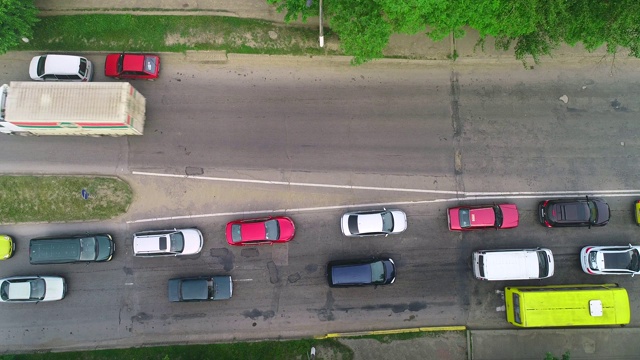 在森林的乡村道路上行驶的许多汽车的空中跟踪视图。4 k。视频素材