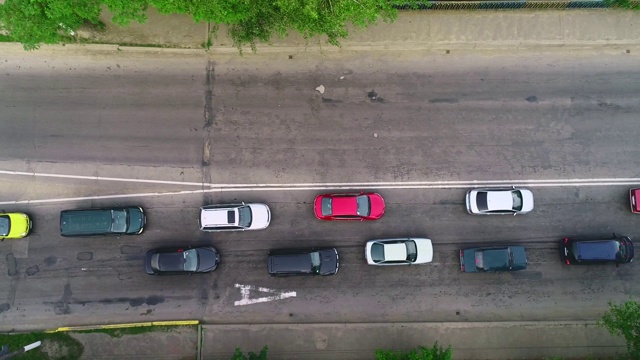 在森林的乡村道路上行驶的许多汽车的空中跟踪视图。4 k。视频素材