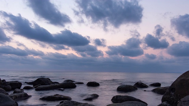 海洋和海滩与岩石在日落，时间流逝视频视频素材