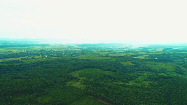 电影空中镜头。一个美丽的小村庄在绿色的夏季森林。4 k。视频素材