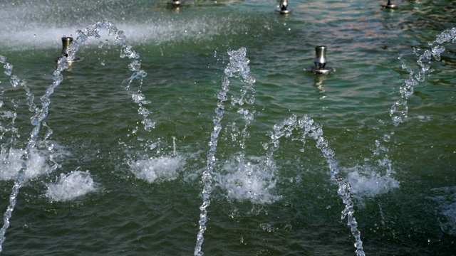 水沿着城市公园喷泉的蓝色陶瓷台阶流淌。视频素材