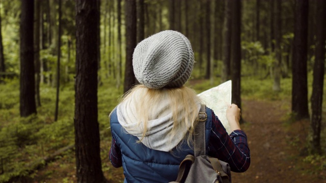 带着地图的旅行者女孩在森林里。视频素材