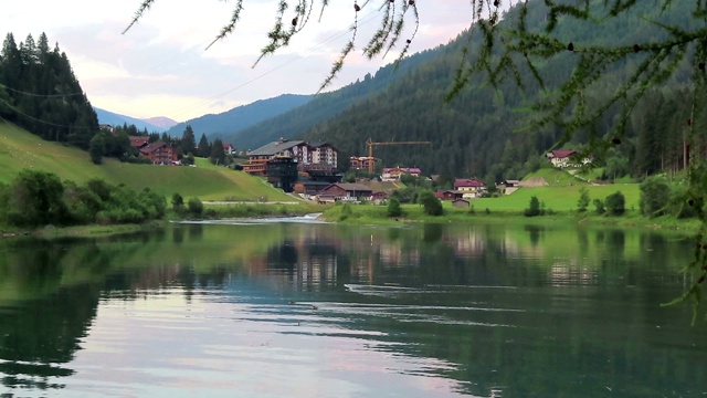 晚上在Tirol(奥地利)的Gerlos湖。水映山映林。村子里的背景。视频素材