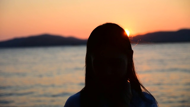 女人站在海滩上的海上日落背景在傍晚黄金时间。暑假去泰国海滩旅游视频素材