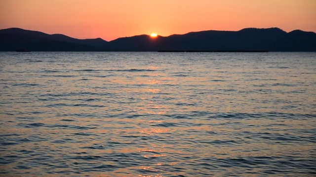 女人站在海滩上的海上日落背景在傍晚黄金时间。暑假去泰国海滩旅游视频素材