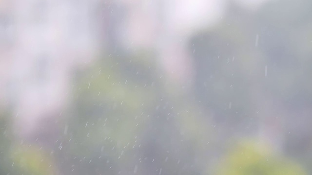 雨滴在空中落下，建筑背景模糊，慢速180帧/秒，暴雨近景。视频素材