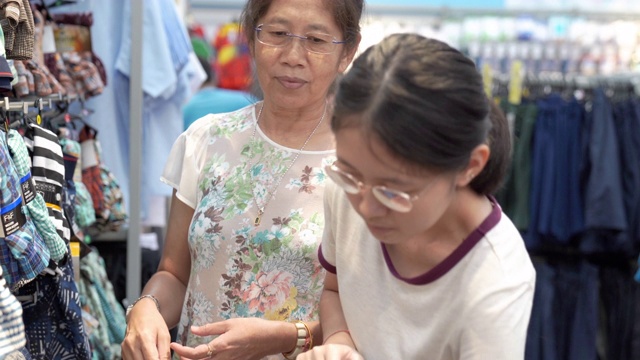 亚洲家庭母亲和十几岁的女孩喜欢在销售商店购物中心度假购物视频素材