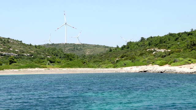 风力涡轮机与地中海和绿色海岸线从游艇甲板上视频素材