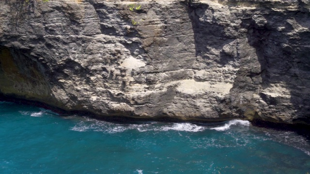 海浪撞击岩石悬崖的破碎海滩努沙佩尼达岛，印度尼西亚巴厘岛的特写视频素材