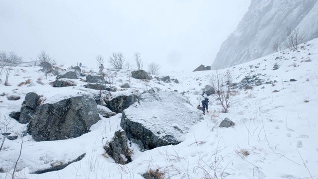 摄影师在暴风雪中徒步登山视频素材