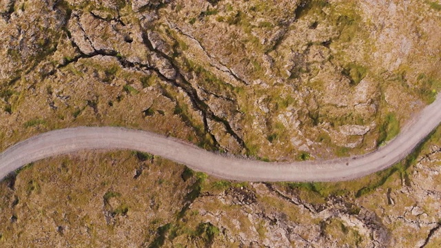 直接俯瞰冰岛一个硬壳火山景观上的单车道土路视频素材