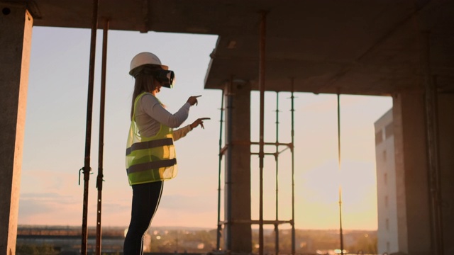 一位建筑工地的女工程师戴着虚拟现实眼镜移动双手，模拟未来建筑施工创新控制界面的工作。视频素材