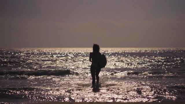 在海里奔跑的女孩和冲浪的海浪视频素材