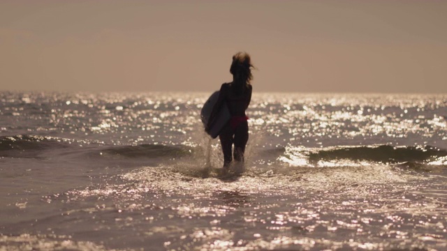 在海里奔跑的女孩和冲浪的海浪视频素材