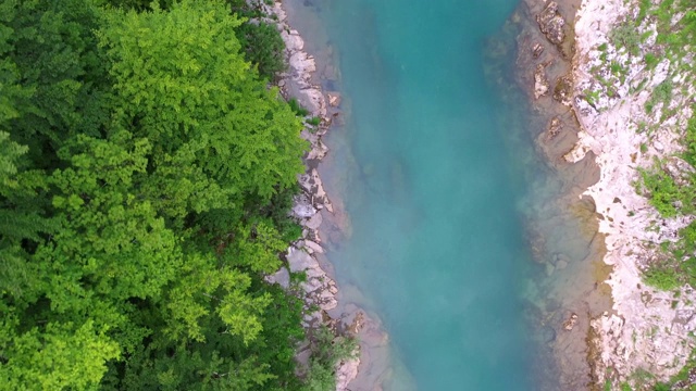 一架四轴飞行器飞越一座山的河流峡谷视频素材