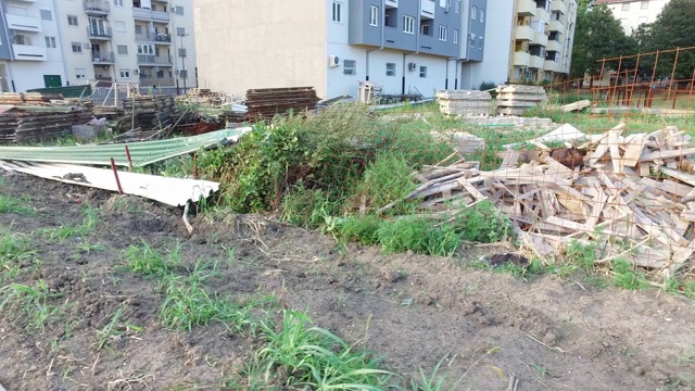 在城市新建住宅楼附近的空建筑空间上，堆放着大量使用过的生锈的钢脚手架或脚手架视频素材