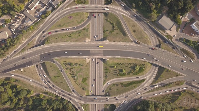 在乌克兰基辅，一架4K高空无人机在夜间道路交通上空飞行。高速公路和立交桥与汽车、卡车、立交、二级公路在大城市交汇。前视图。视频素材