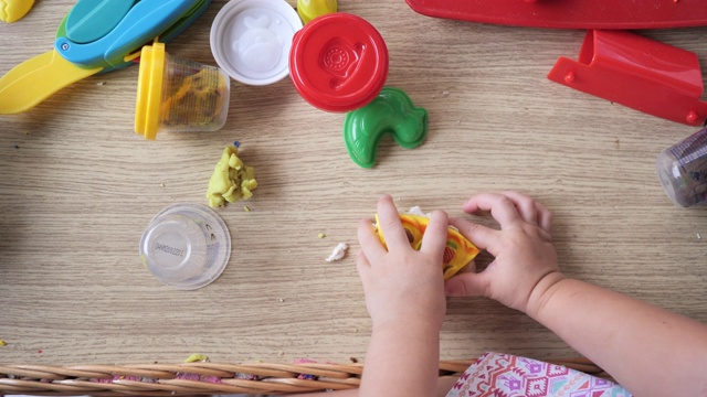 蹒跚学步的小女孩玩黏土慢动作视频视频素材