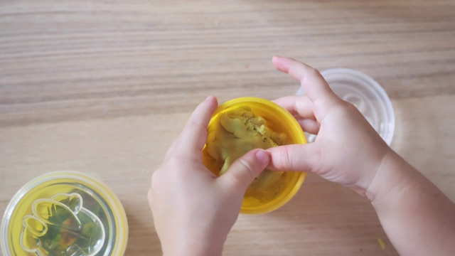 蹒跚学步的小女孩玩黏土慢动作视频视频素材