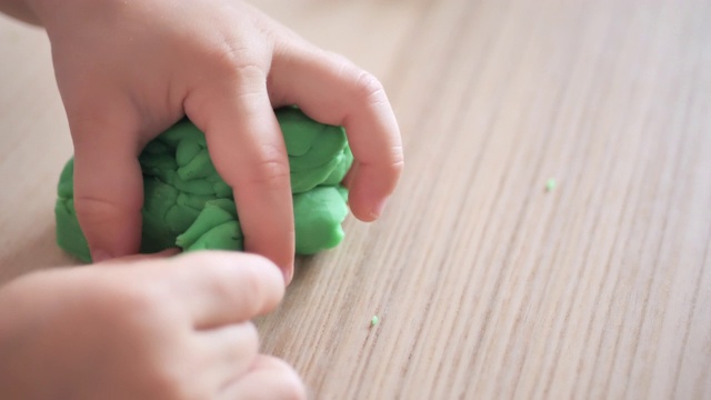 蹒跚学步的小女孩玩黏土慢动作视频视频素材