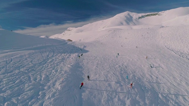 4k视频，顶部无人机拍摄的业余滑雪者从山上滑雪下来的画面视频下载