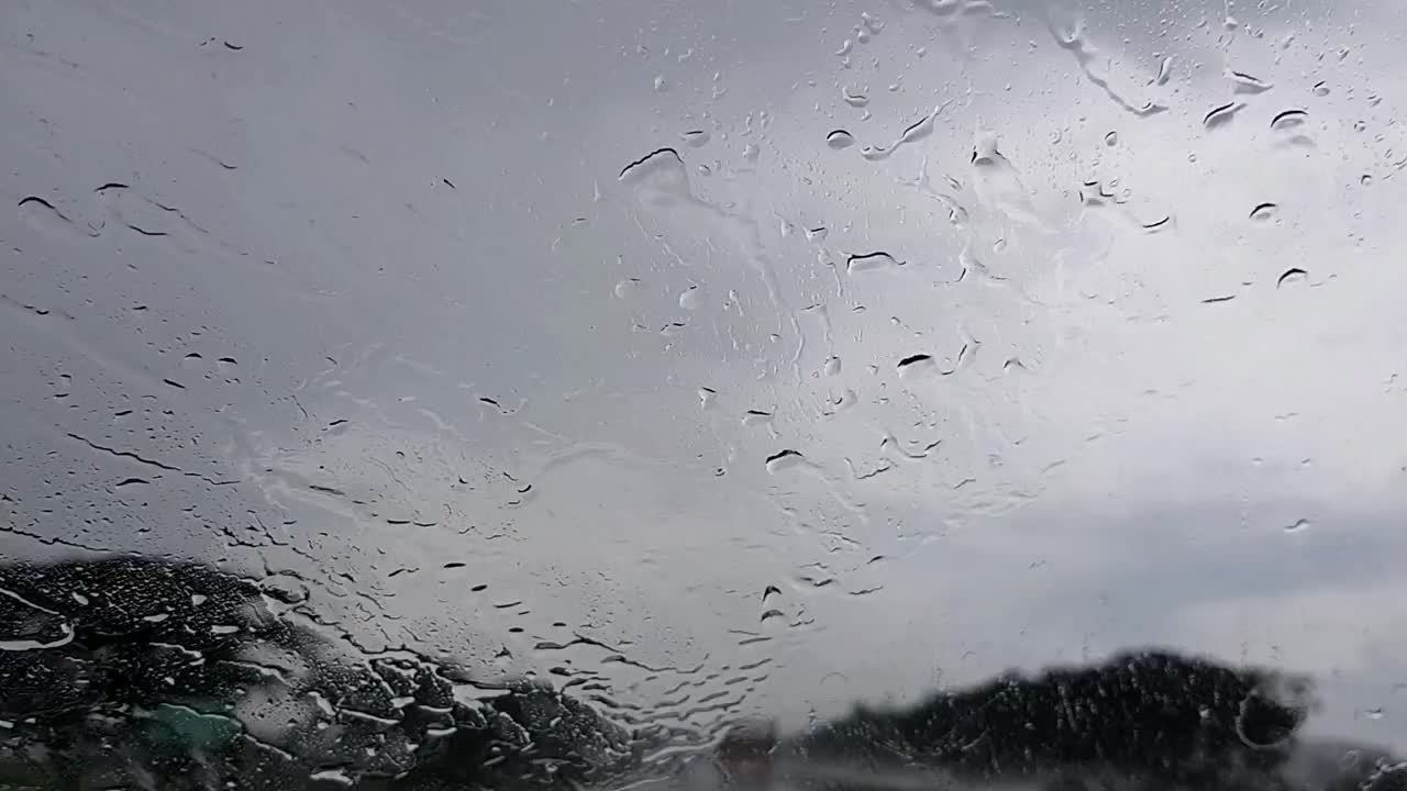 雨天在高速公路上开车，雨刷在结霜的挡风玻璃上，白天能见度很差视频下载