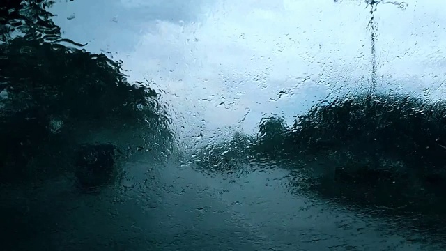 在雨中行驶在高速公路上，白天能见度很低，雨刷在磨砂的挡风玻璃上视频素材