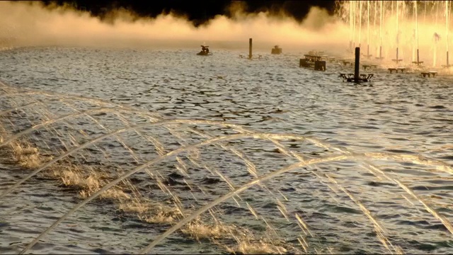 在罗马尼亚布加勒斯特的自流泉(Fantana lui Bucur)的夕阳下，喷泉的背景是有趣的水蒸汽。4K DCI, 200mbps。视频下载