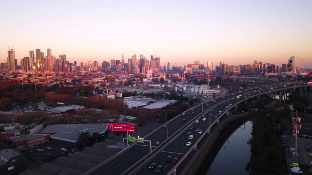 夕阳下的墨尔本CBD与城市高速公路的航拍视频素材