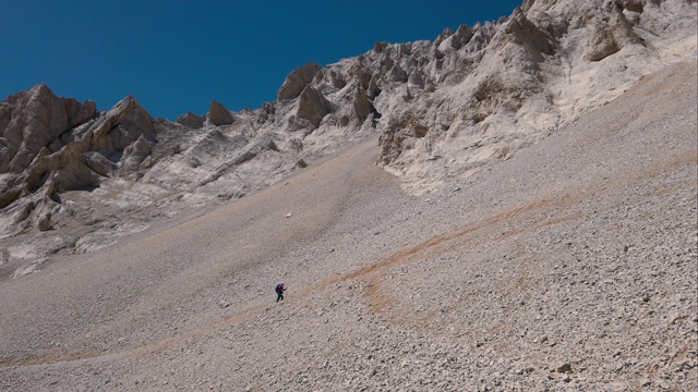 一位女登山者正走向一座山的顶峰视频素材