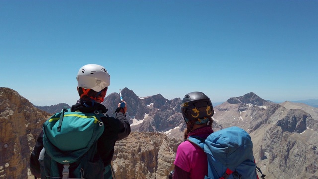 登山队长在山顶给队友指路视频素材