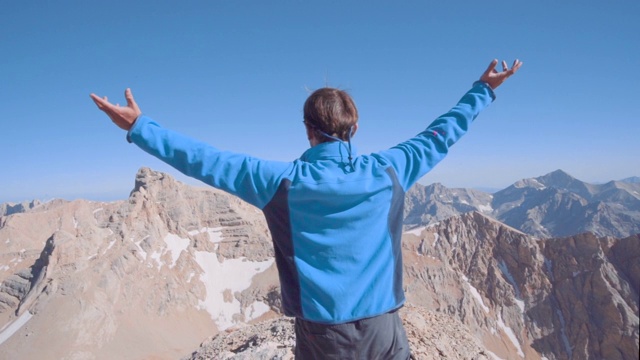 登山运动员在山顶张开双臂庆祝成功视频素材