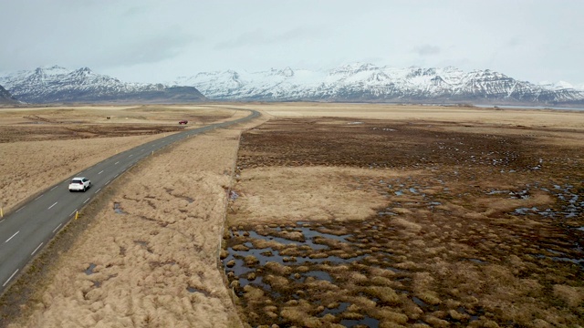 冰岛火山景观上的美丽道路。无人机在汽车后面飞行。视频素材