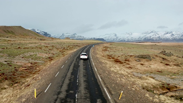 冰岛火山景观上的美丽道路。无人机在汽车后面飞行。视频素材