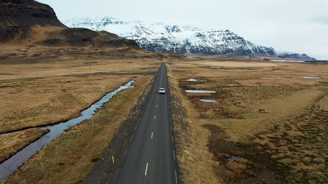 冰岛火山景观上的美丽道路。无人机在汽车后面飞行。视频素材