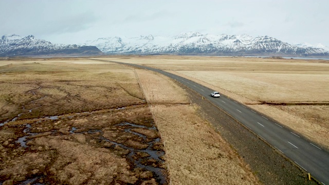 冰岛火山景观上的美丽道路。无人机在汽车后面飞行。视频素材