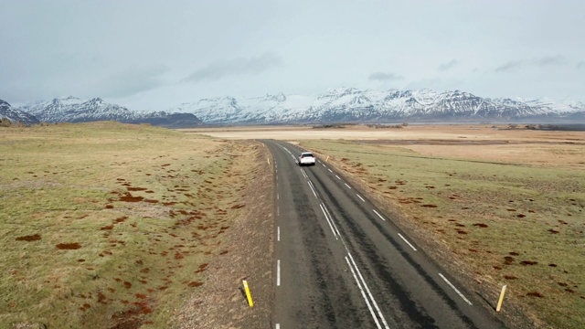 冰岛火山景观上的美丽道路。无人机在汽车后面飞行。视频素材