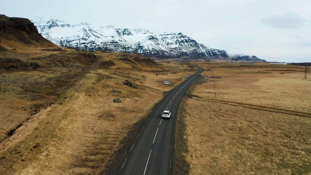 冰岛火山景观上的美丽道路。无人机在汽车后面飞行。视频素材