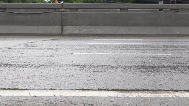 在雨季，汽车在雨水淋湿的道路上行驶视频素材