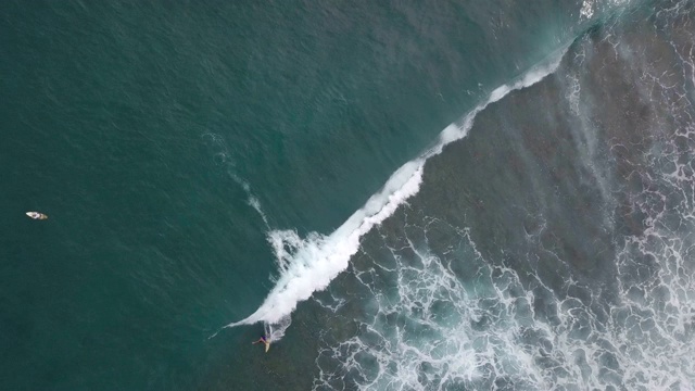 顶部鸟瞰冲浪者骑在海浪上的海洋视频素材