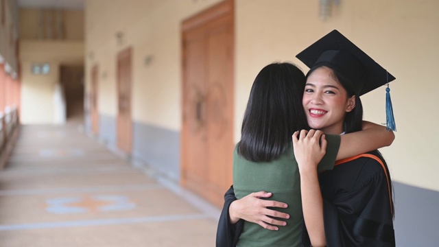 女性肖像，大学毕业生穿着黑色的褶边裙，戴着黑色的帽子和蓝色的流苏。视频素材