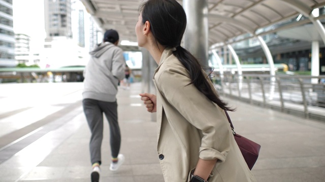 强盗在户外从年轻亚洲女子那里偷手机视频素材