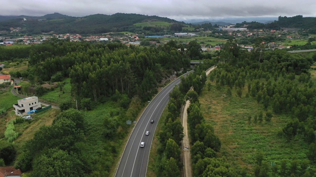 从上面鸟瞰图的乡村道路通过绿色的夏季森林在夏天视频素材