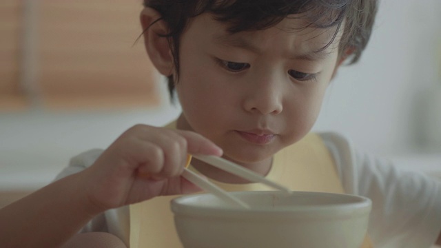 奶奶和孙女在餐桌上吃面条视频素材