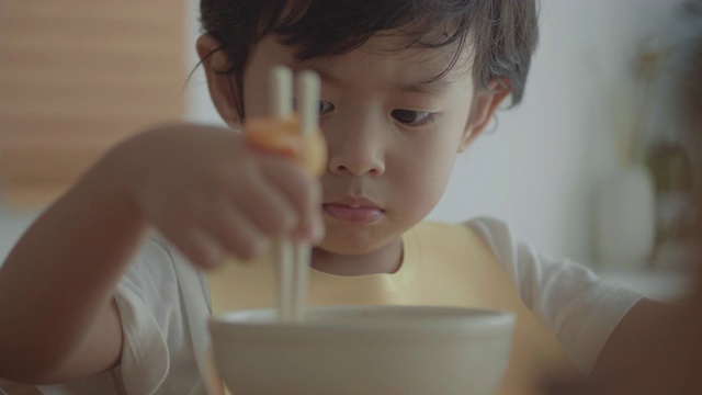 奶奶和孙女在餐桌上吃面条视频素材