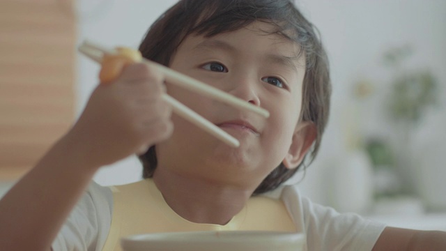 奶奶和孙女在餐桌上吃面条视频素材